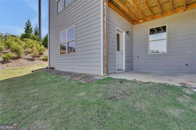 doorway to property with a yard and a patio