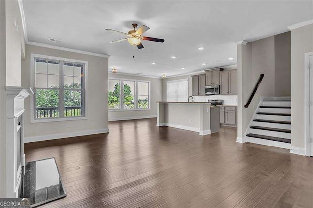 unfurnished living room with crown molding, ceiling fan, and dark hardwood / wood-style flooring