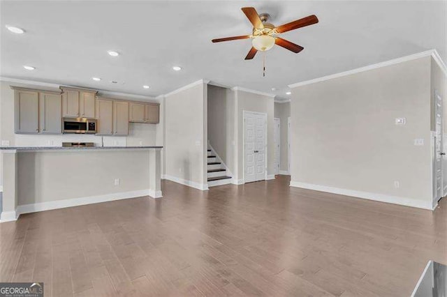 unfurnished living room with crown molding, dark wood-type flooring, and ceiling fan