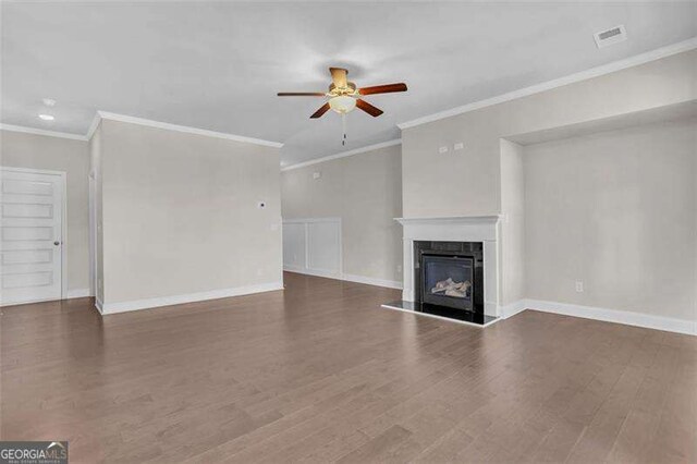 unfurnished living room featuring crown molding, ceiling fan, and dark hardwood / wood-style flooring