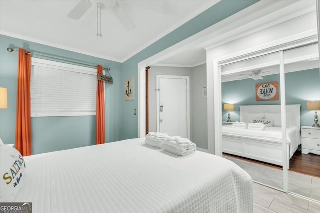 bedroom with crown molding, ceiling fan, and a closet