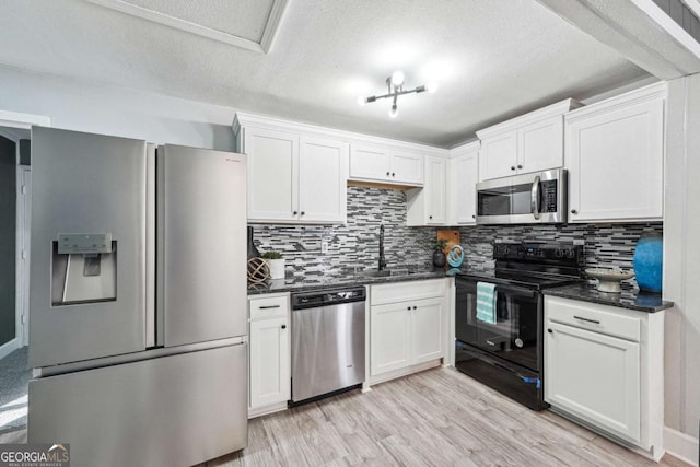 kitchen with stainless steel appliances, light hardwood / wood-style floors, sink, and white cabinets