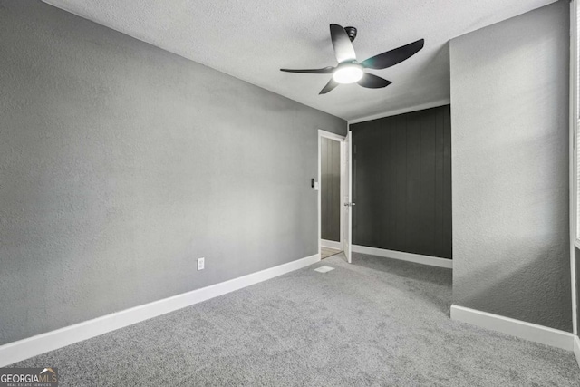 unfurnished bedroom featuring ceiling fan, carpet, and a textured ceiling