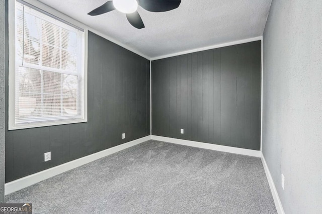 carpeted spare room with ceiling fan and a textured ceiling