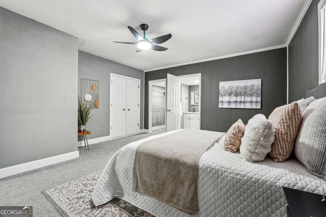 bedroom featuring connected bathroom, ornamental molding, wooden walls, carpet floors, and ceiling fan