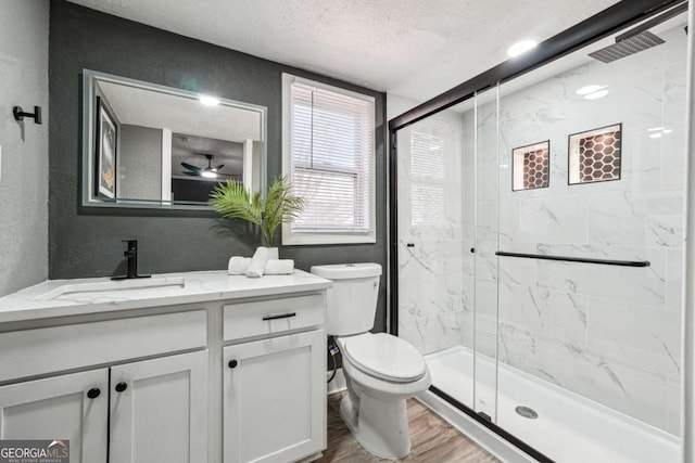 bathroom featuring vanity, an enclosed shower, wood-type flooring, a textured ceiling, and toilet