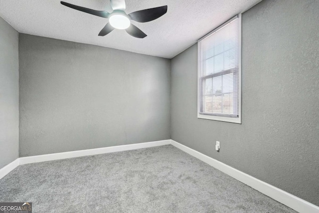 carpeted empty room featuring ceiling fan and a textured ceiling