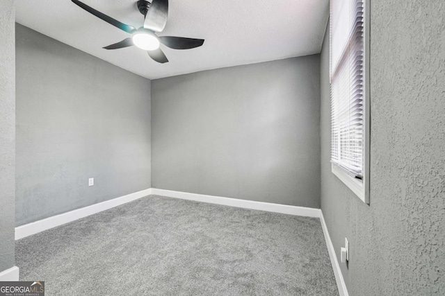 carpeted spare room with ceiling fan and a textured ceiling