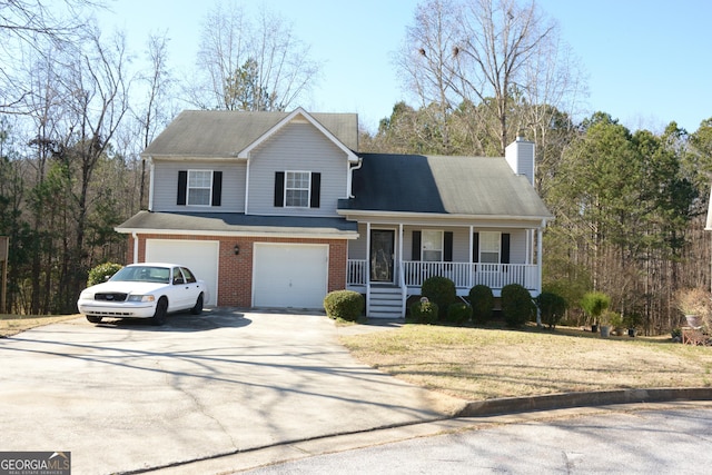 split level home with a porch, a garage, brick siding, and driveway