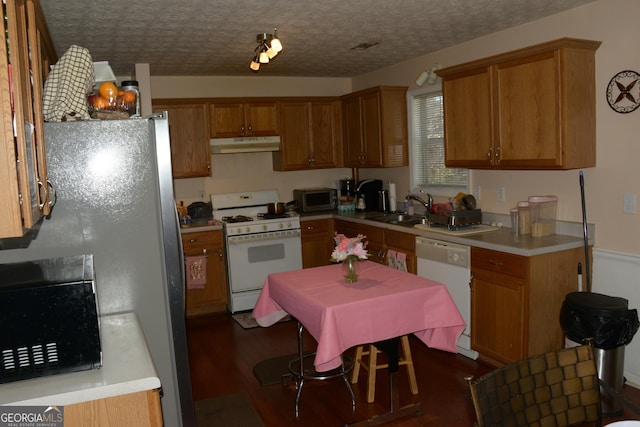 kitchen with sink, dark wood-type flooring, a textured ceiling, and appliances with stainless steel finishes