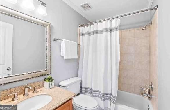 full bathroom with shower / tub combo, vanity, and toilet