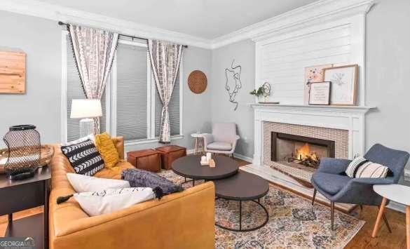 sitting room with hardwood / wood-style flooring, ornamental molding, and a tile fireplace