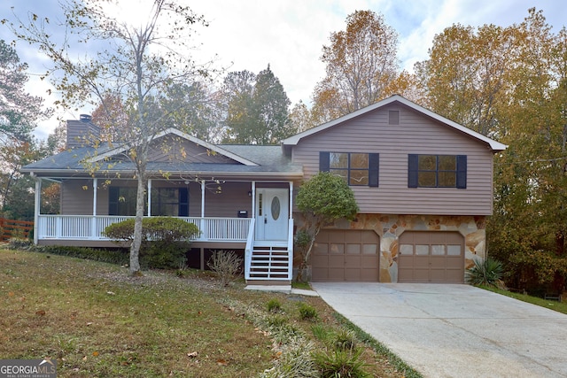 view of front facade featuring a garage, a front yard, and covered porch