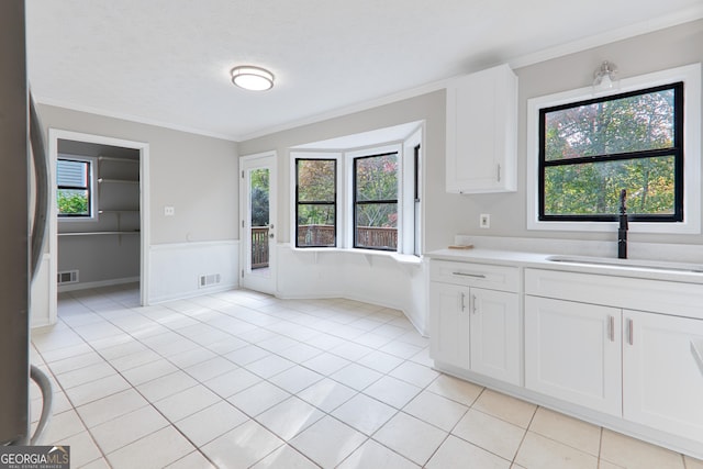 kitchen with stainless steel fridge, plenty of natural light, sink, and white cabinets