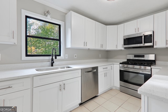 kitchen with sink, light tile patterned floors, stainless steel appliances, and white cabinets