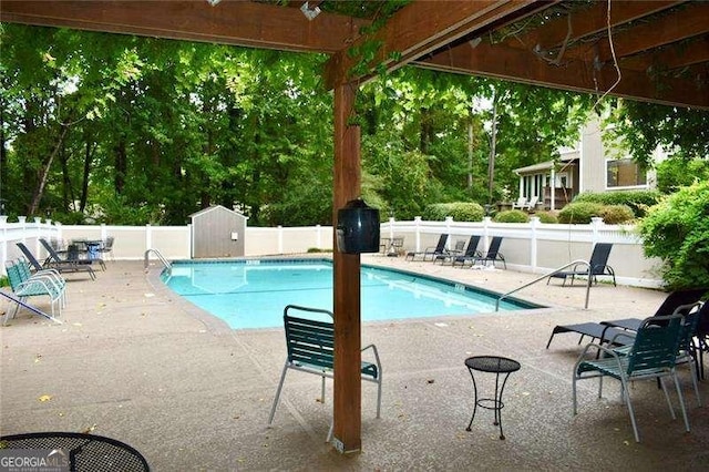 pool featuring a fenced backyard, an outbuilding, a storage shed, and a patio