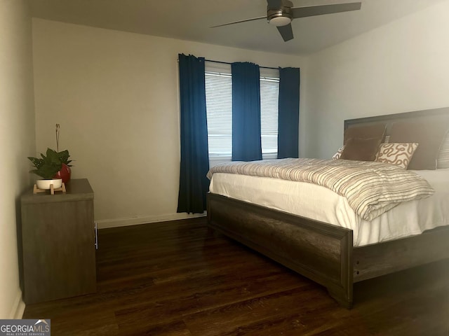 bedroom featuring baseboards, wood finished floors, and a ceiling fan