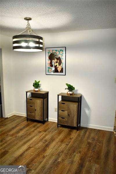 corridor featuring dark hardwood / wood-style floors and a textured ceiling