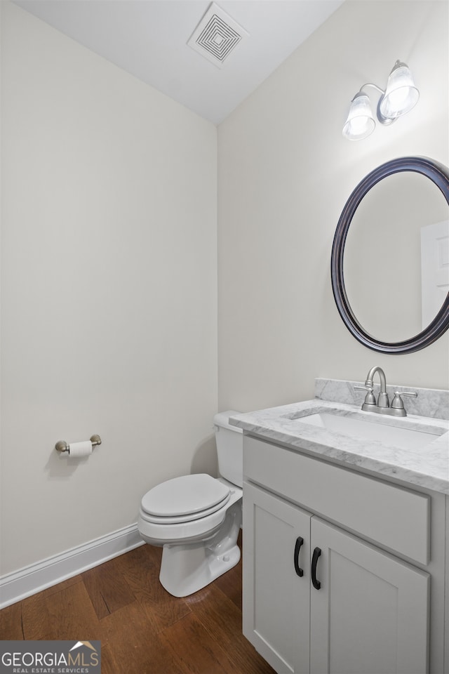 bathroom featuring vanity, hardwood / wood-style floors, and toilet