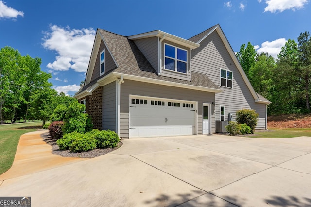 view of side of property with a garage and central AC