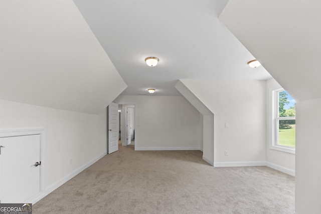 bonus room featuring vaulted ceiling and light colored carpet