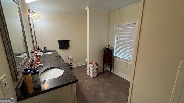 bathroom featuring crown molding, vanity, and toilet