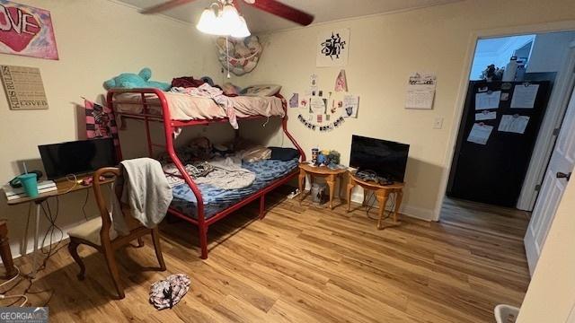 bedroom featuring wood-type flooring, refrigerator, and ceiling fan