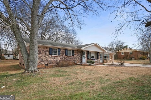 ranch-style home featuring covered porch and a front lawn