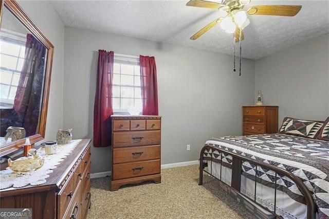 bedroom with light colored carpet, a textured ceiling, and ceiling fan