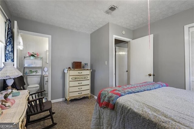 bedroom with dark carpet and a textured ceiling