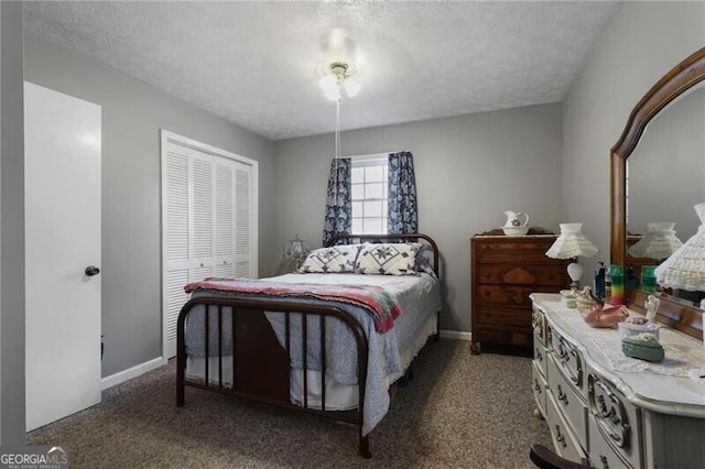 bedroom featuring a closet, a textured ceiling, and dark colored carpet