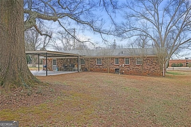 rear view of house with a yard and a patio area