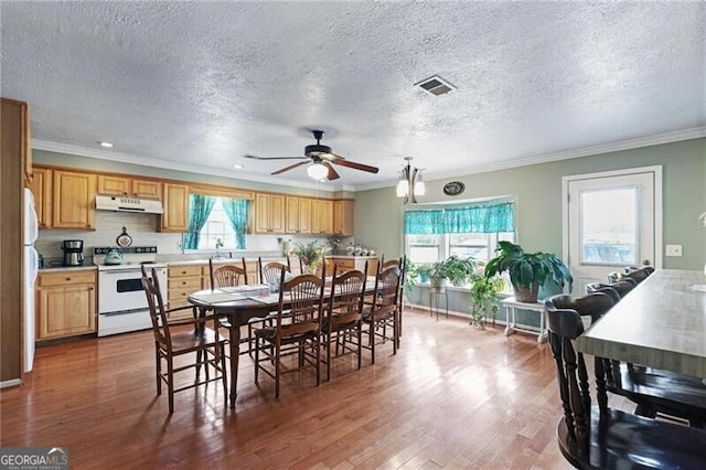 dining room featuring ornamental molding, hardwood / wood-style floors, ceiling fan, and a textured ceiling