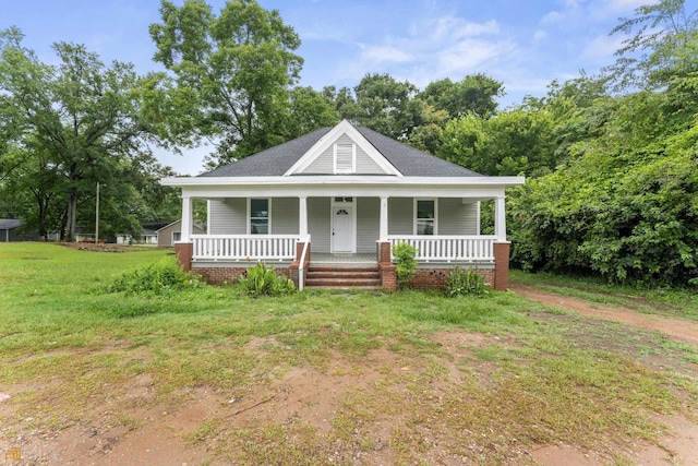 farmhouse inspired home with a front yard and covered porch