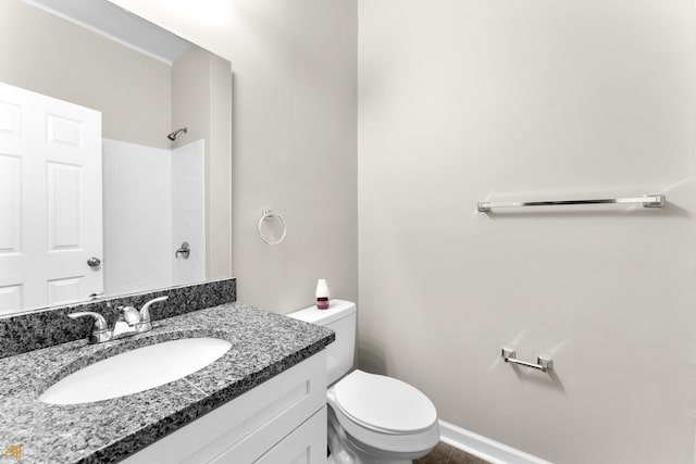 bathroom featuring vanity, a shower, and toilet