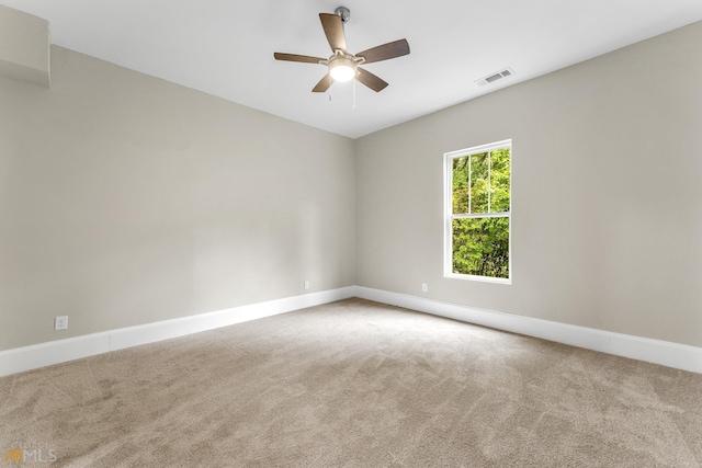 carpeted spare room with ceiling fan