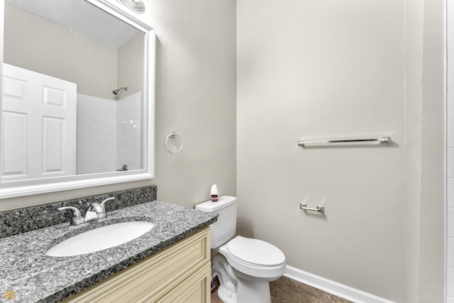 bathroom featuring vanity, walk in shower, and toilet