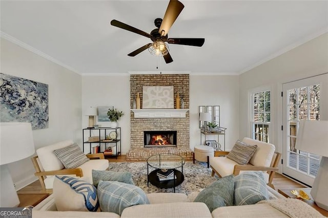 living room featuring ornamental molding, a brick fireplace, hardwood / wood-style floors, and ceiling fan