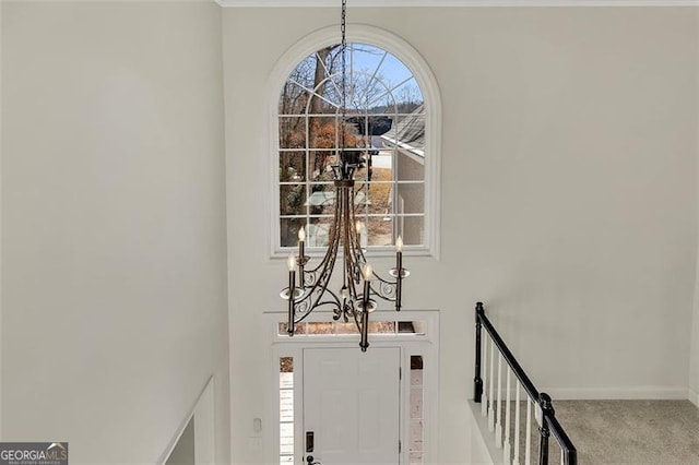 entrance foyer with carpet floors and a chandelier