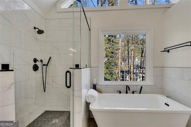 bathroom featuring shower with separate bathtub, lofted ceiling, and tile walls