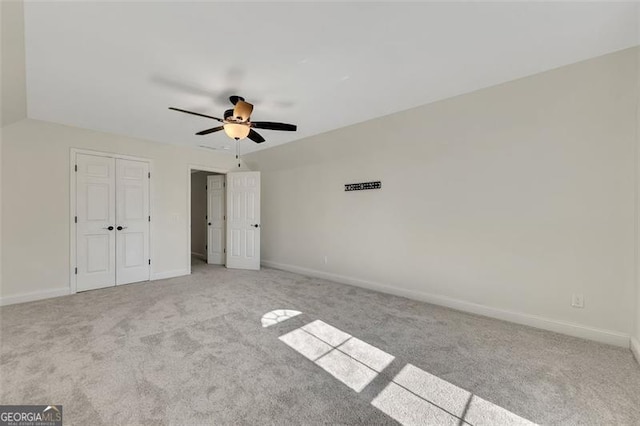 unfurnished bedroom featuring light carpet, a closet, and ceiling fan