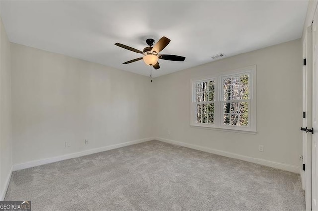 carpeted spare room with ceiling fan