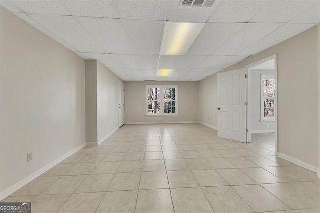 tiled spare room featuring a paneled ceiling