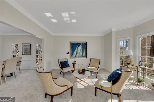 sitting room with crown molding and light colored carpet