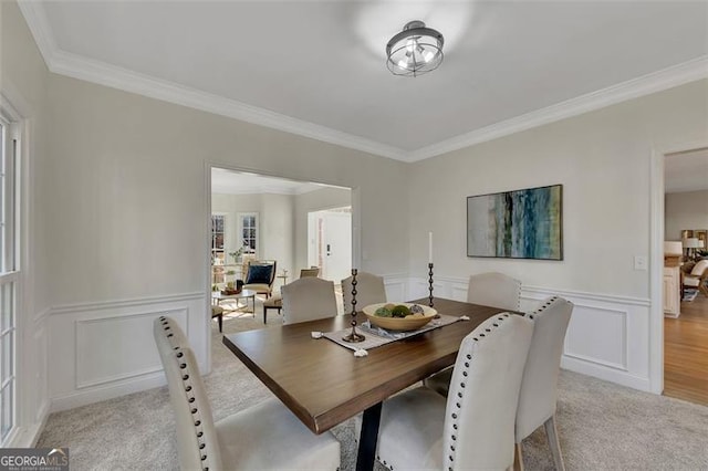 carpeted dining area featuring crown molding