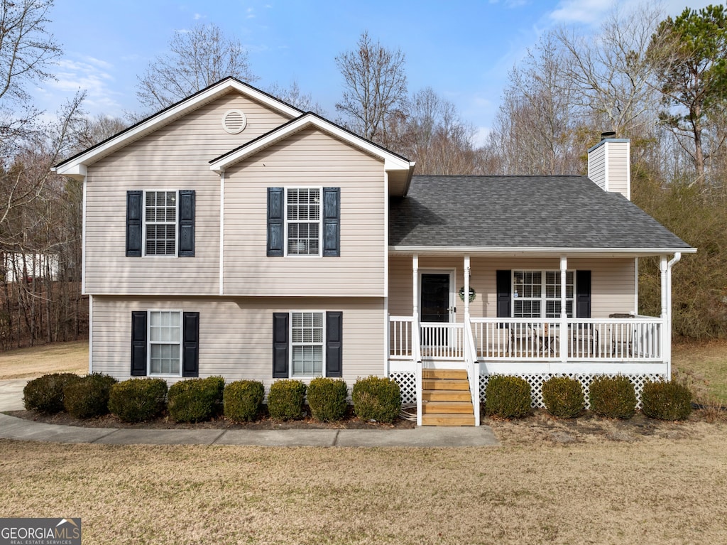 tri-level home featuring a front yard and covered porch