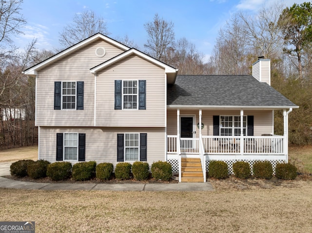 tri-level home featuring a front yard and covered porch