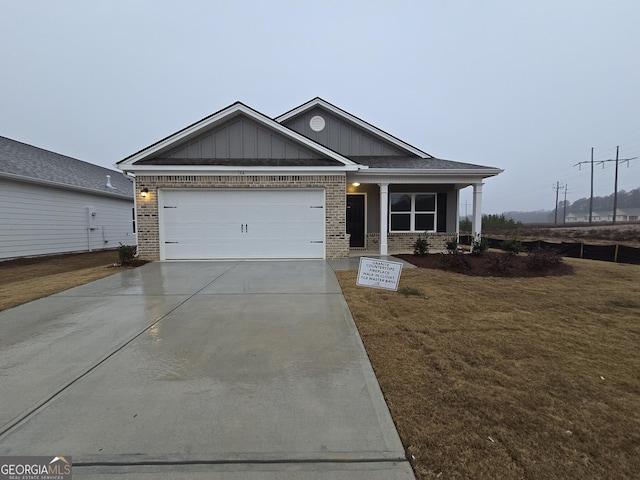 craftsman inspired home featuring a garage and a front lawn