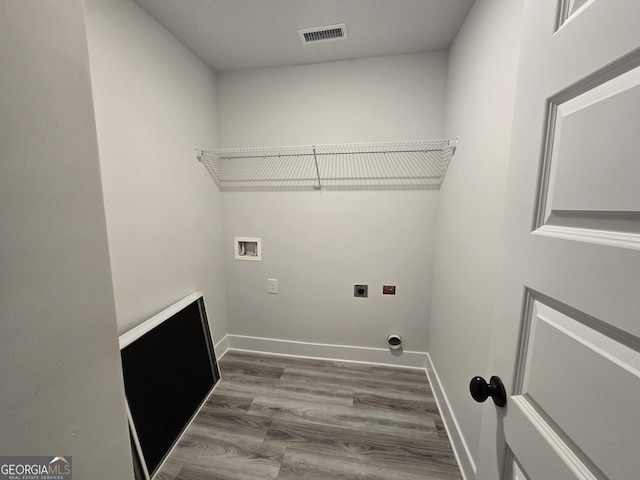 washroom featuring hookup for a washing machine, electric dryer hookup, and dark wood-type flooring