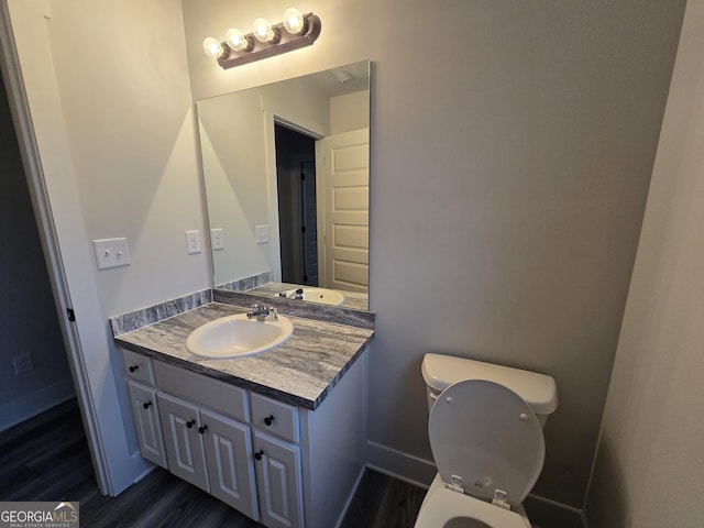 bathroom with wood-type flooring, vanity, and toilet